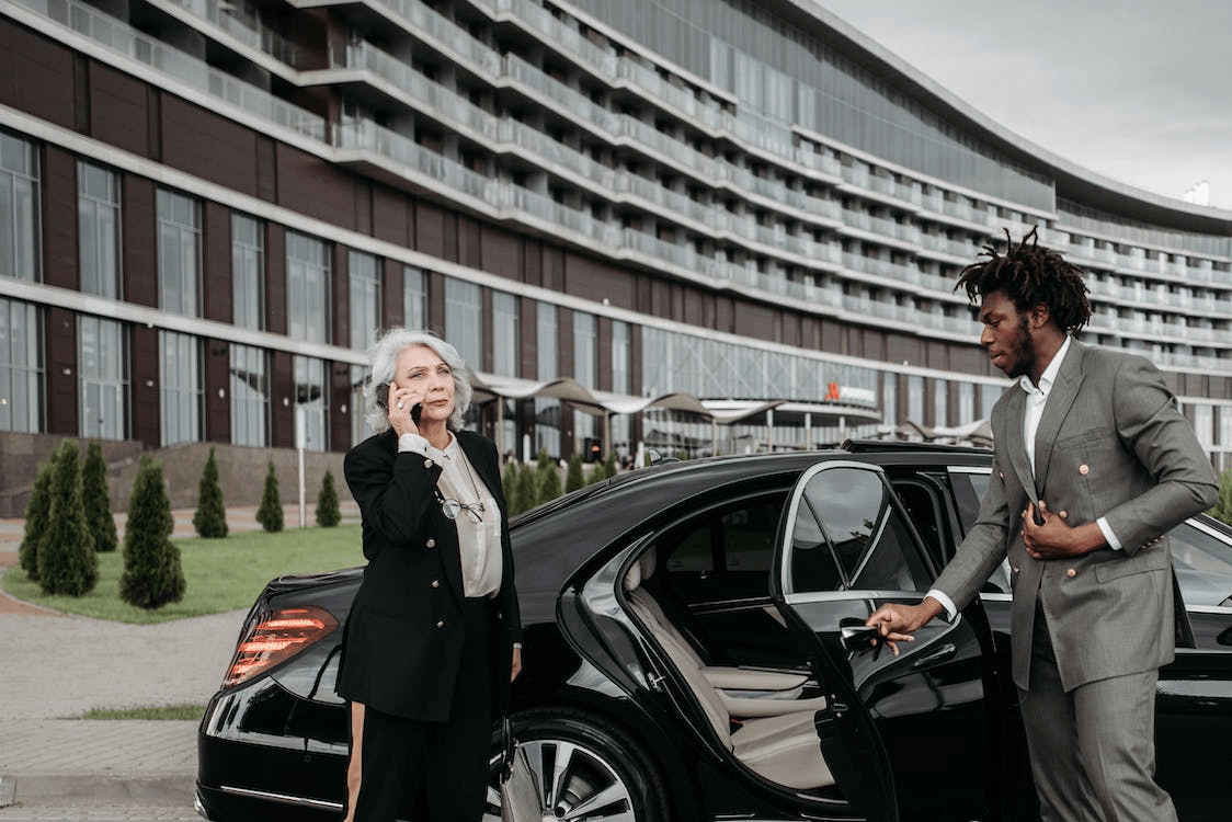 A business person and chauffeur outside an executive car