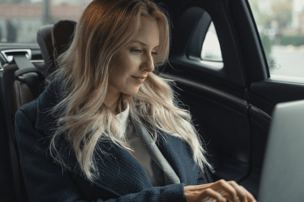 An executive working on a laptop in the car