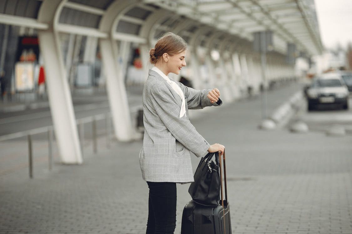 Woman waiting for transport with luggage