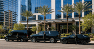 Luxury corporate transportation fleet with Mercedes Sprinter, Cadillac Escalade SUV, and executive sedan outside a Phoenix office building.